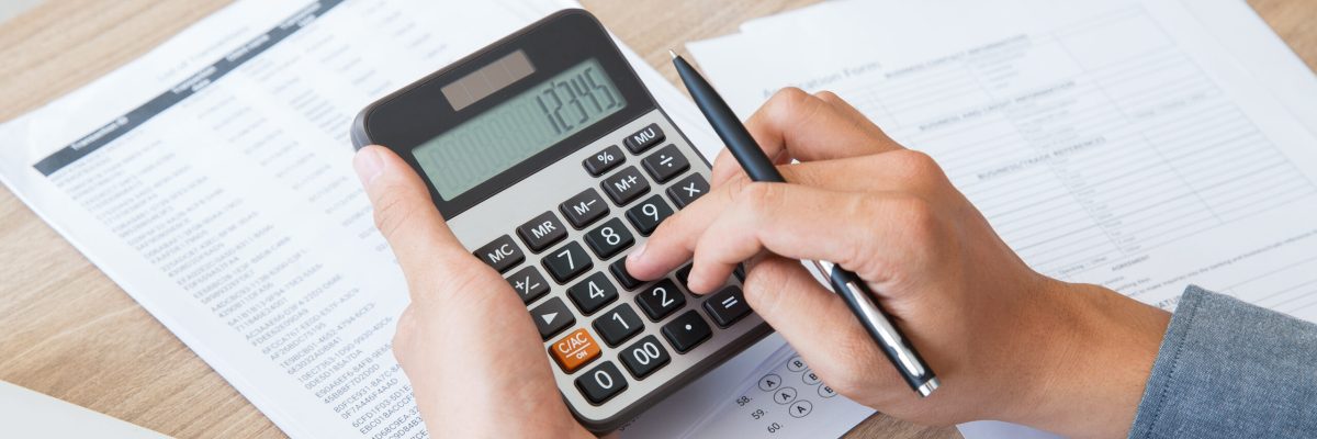 Man Using Calculator To Count Income And Outcome - AM Contabilidade